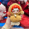 A hand holds a Skullpanda You Found Me! Series mystery box collectible figure with orange hair and a fluffy brown body.