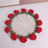 Hand-crocheted lily of the valley coasters featuring red and green textured fabric flowers