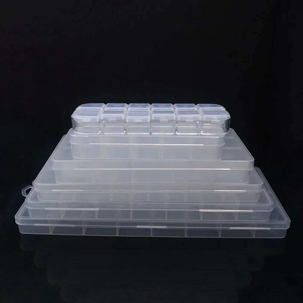 A stack of clear plastic storage boxes with dividers for jewelry and craft supplies