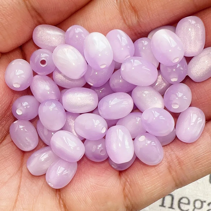 A handful of iridescent lavender and pink resin star-like cat's eye beads for jewelry making