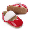 A bright red lace-trimmed moccasin shoe for a baby girl with white faux fur trim.