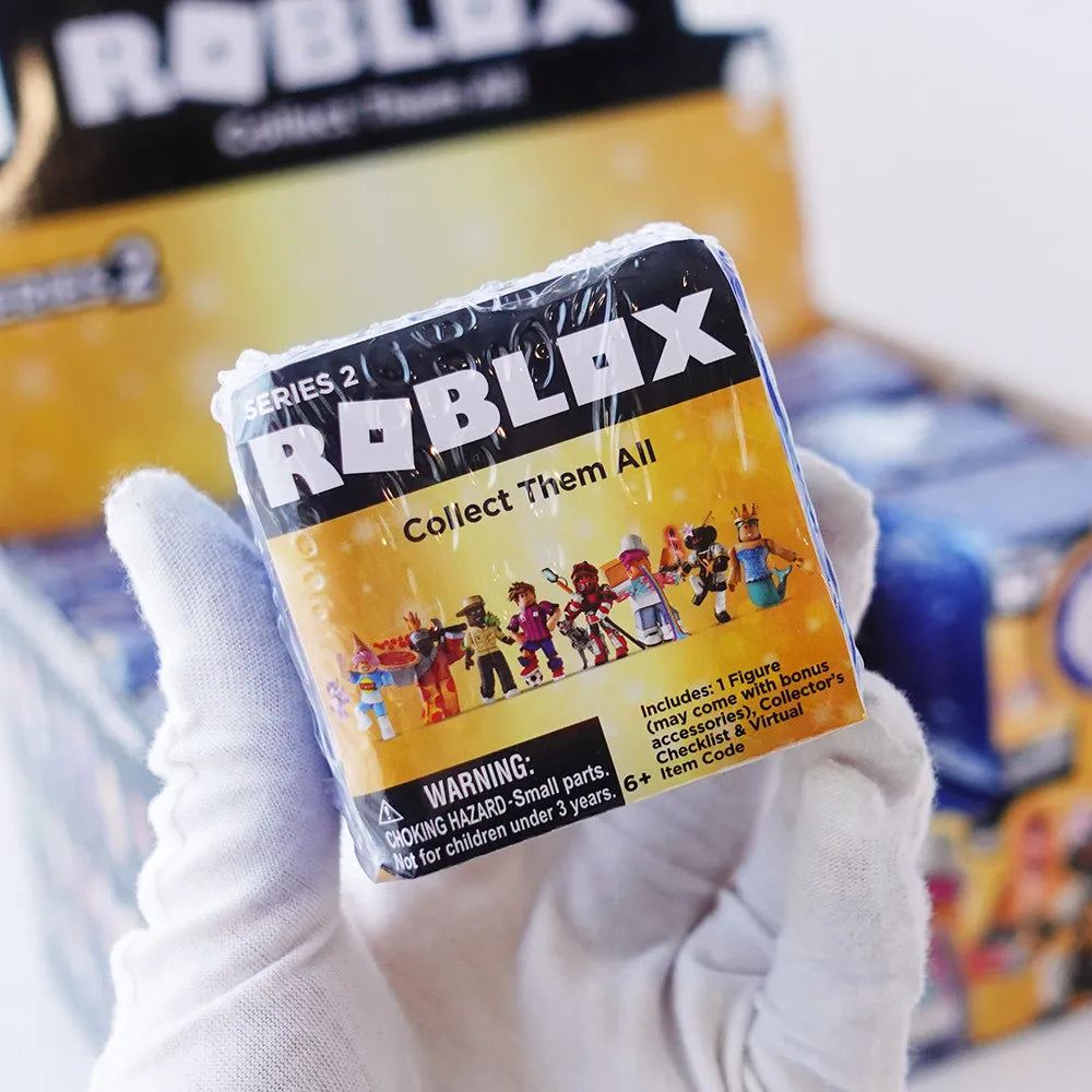 A hand holds a Roblox Collect Them All figure packaged in its plastic case.
