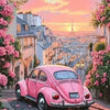 A pink vintage car is parked on a cobblestone street with lush pink flowers and buildings in the background under a sunset sk