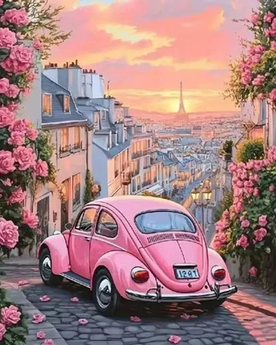 A pink vintage car is parked on a cobblestone street with lush pink flowers and buildings in the background under a sunset sk