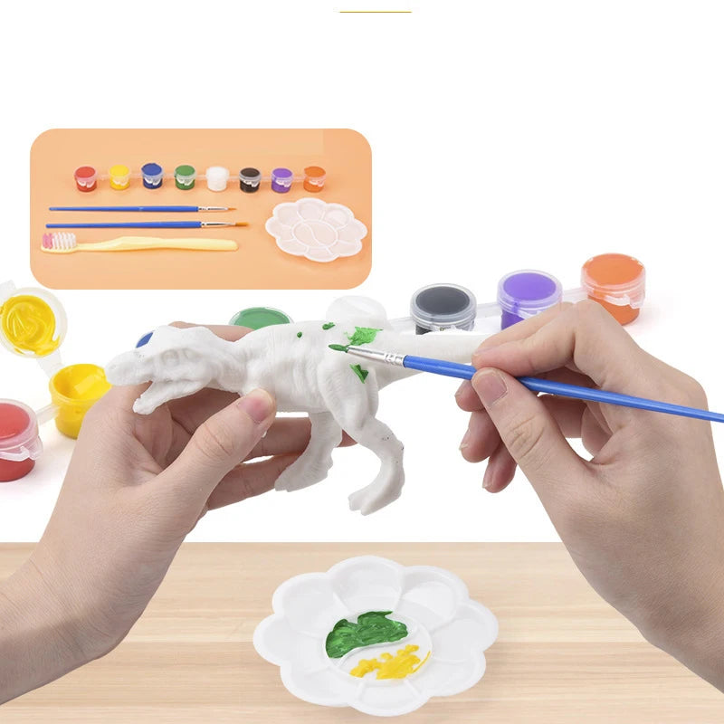 Hands paint a white dinosaur model with various colored paints and brushes on a wooden table.