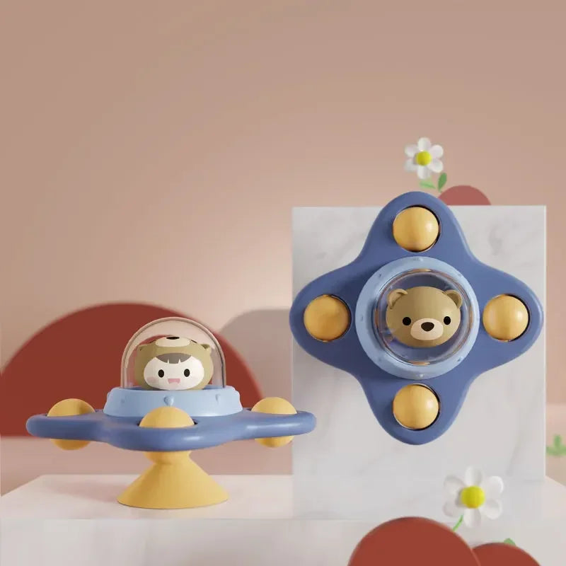 A set of blue and yellow suction cup spinner bath toys for toddlers featuring a bear face.