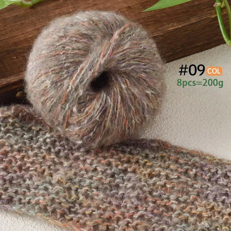 A ball of soft alpaca blend yarn with multicolored fibers resting on a knitted fabric.