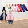 A display of colorful kids' cartoon hooded puffer jackets hanging on a wooden rack.