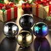 A collection of shiny metal fidget spinners in various colors resting on a dark surface next to wrapped gifts.