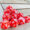 A collection of ten red acrylic D20 dice scattered on a wooden surface.