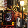 A close-up of a DIY wooden book nook kit featuring train elements and warm LED lighting.