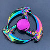 A colorful metal fidget spinner shaped like a dragon, featuring iridescent green and pink hues.