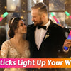 A couple is holding glow sticks during a wedding party, illuminating the scene with colorful light.