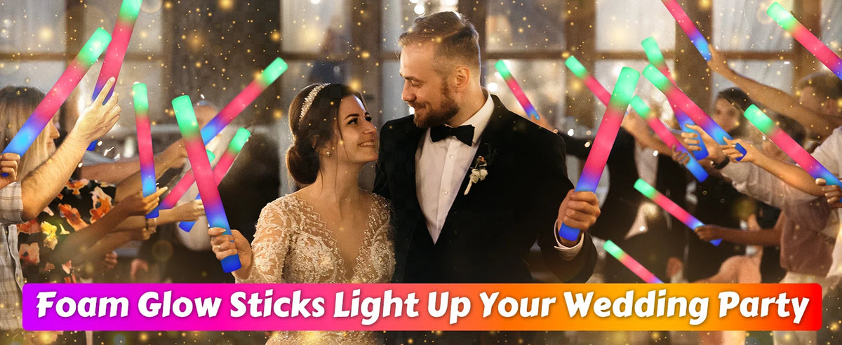 A couple is holding glow sticks during a wedding party, illuminating the scene with colorful light.