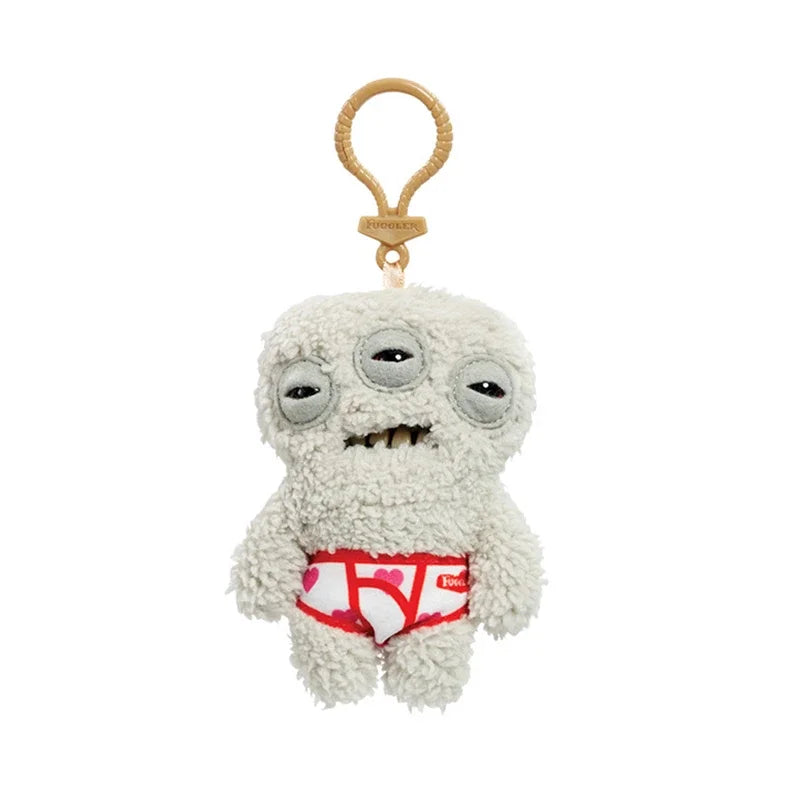 A light gray plush monster keychain with a rabbit design and a pink and red diaper detail.