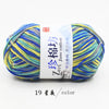 A ball of multi-colored yarn featuring blue, yellow, and green threads labeled as Zime Cotton Yarn.