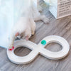 A white cat paw is interacting with a white, oval-shaped interactive toy for cats on a gray surface.