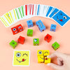 A hand holds a yellow face-changing cube puzzle game with smiling eyes and a mouth, surrounded by various colored wooden cube