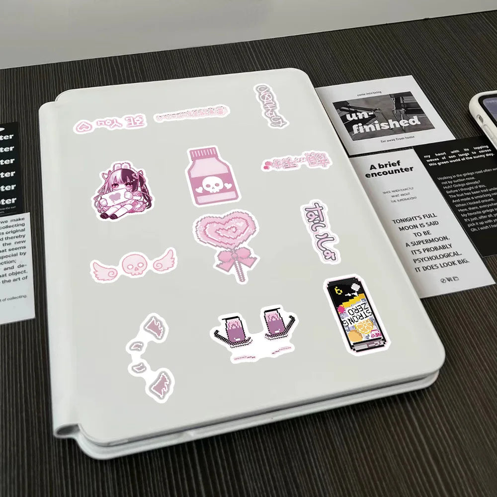 A white notebook features various pink and purple aesthetic stickers, including illustrations of a cat, heart, and phone.