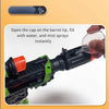 A hand is shown operating an LED light-up water mist blaster toy gun, preparing to spray water from the barrel tip.