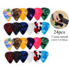 A variety pack of 24 guitar picks in different colors and sizes with an adhesive holder shown next to a guitar.