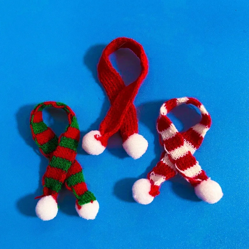 A set of three red and white knitted rubber duck accessories including a hat, scarf, and other items on a blue background.