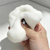 A hand holds a white squishy fidget block with a star design for stress relief and sensory play.