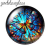 A round glass cabochon featuring a vibrant blue and orange butterfly design.