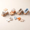 A set of wooden train cars painted in various colors and numbered blocks 1 through 4 for a Montessori educational toy.
