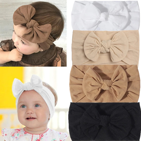 Ein Set aus drei Baumwoll-Baby-Haarbändern in Braun, Weiß und Schwarz.
