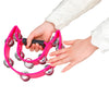 A hand is holding a bright pink double-layer tambourine with metal bells for kids.