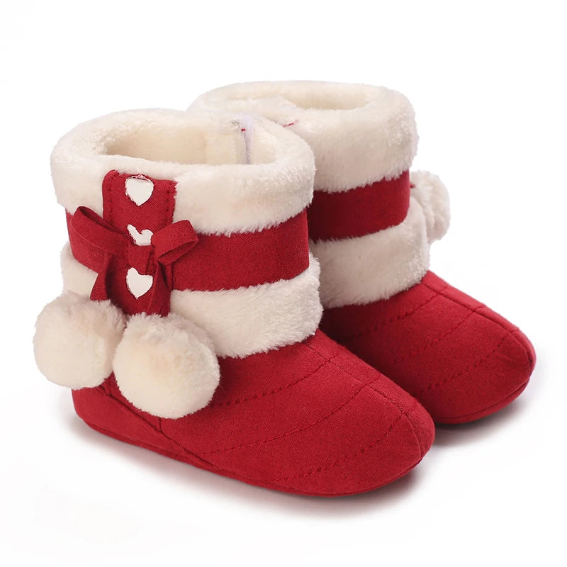 Pair of red and white faux fur baby first walker shoes with a bow detail