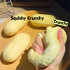 A hand squeezes a yellow squishy crunchy fidget toy shaped like a peanut.