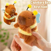 A brown capybara plush toy with yellow accents and bee-like features being held by a person.