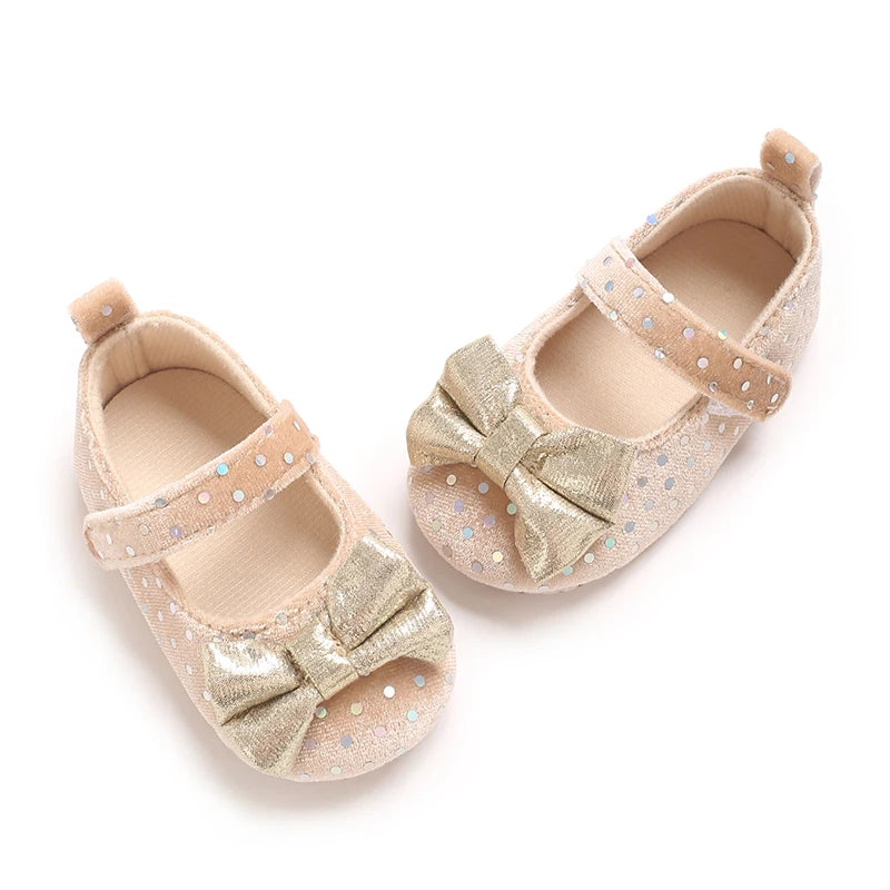 Pair of light pink soft cotton baby walking shoes with gold glitter bow details