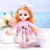 An 17cm articulated princess doll with long orange hair wearing a pink and white floral dress and a pink bow.