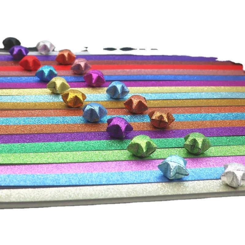 Colorful glitter origami star paper strips arranged in horizontal rows for crafting and decorating