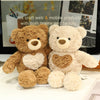 A pair of fluffy brown and cream teddy bears sitting side by side on a white surface.