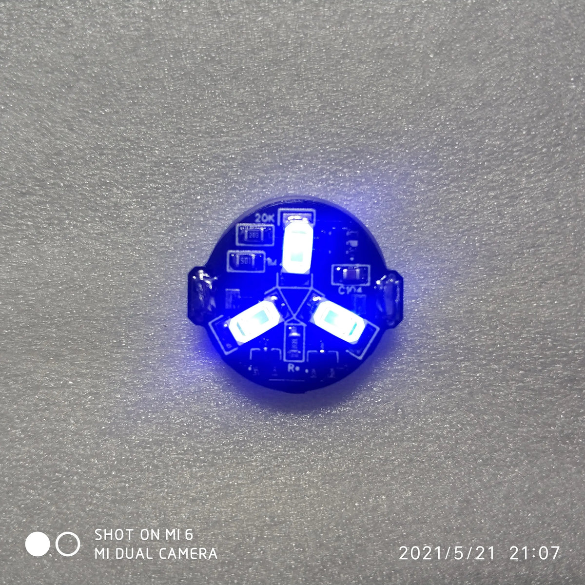 A blue magnetic LED diorama light with a remote control is shown against a gray background.