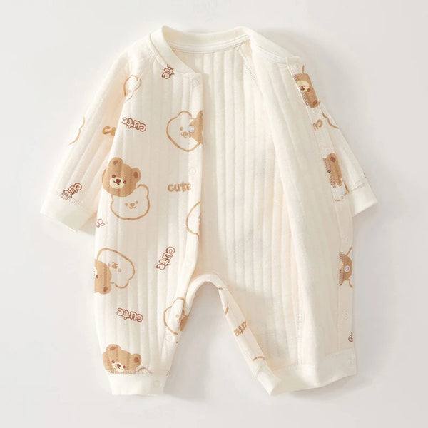 A cream-colored cotton jumpsuit for infants featuring a pattern of cute bear faces and text.