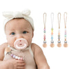 Ein Baby hält einen Silikon-Milchflaschenclip mit mehreren farbigen Silikon-Milchflaschen und Clips.