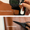A close-up of a digital thickness gauge measuring moderate thickness on brown PU leather, next to scissors labeled scratch re