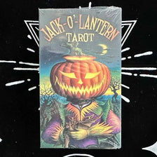 A deck of Jack-O'-Lantern Tarot cards featuring a carved pumpkin and mystical imagery.