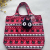 A pink and black patterned tote bag featuring a repeating cat design, placed on a white surface.