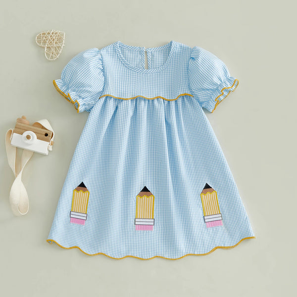 Hellblaue karierte A-Linienkleid für Mädchen mit Rüschenärmeln und gelbem Zierrand, neben einem Holzbleistift.