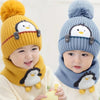 A child models a yellow knit penguin hat and matching scarf set.