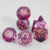 A set of glitter polyhedral dice including a D4, D6, D8, D10, D12, and D20, made of translucent pink and purple resin.