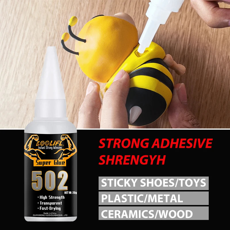 A hand is applying a bottle of Strong Adhesive Shrengyh super glue to a yellow bee-shaped tool for repair.