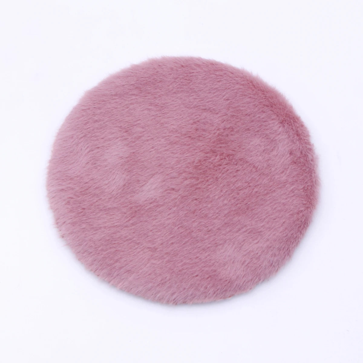 A round, pink felt mat with a fluffy texture used for dollhouse decor.