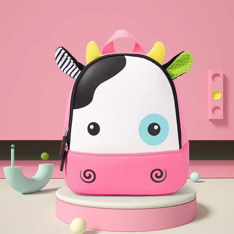 A pink and white cartoon horse backpack with large blue eyes and yellow accents sitting on a light pink stand.